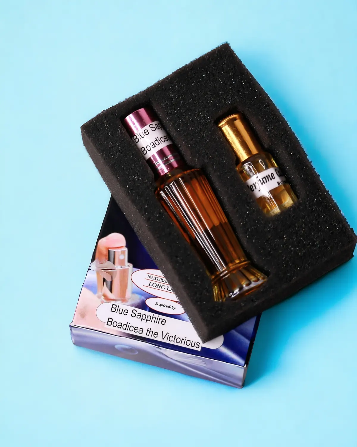 A ribbed glass bottle of perfume oil in a foam tray on a blue background